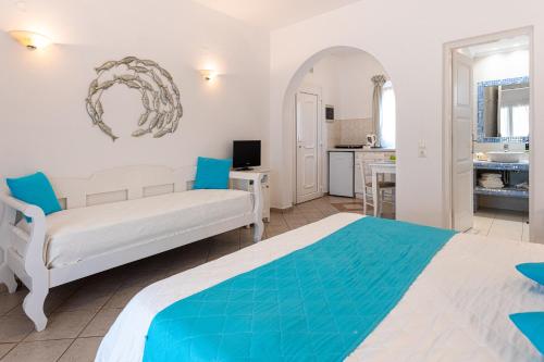 a bedroom with a bed and a living room at Reverie Santorini Hotel in Firostefani