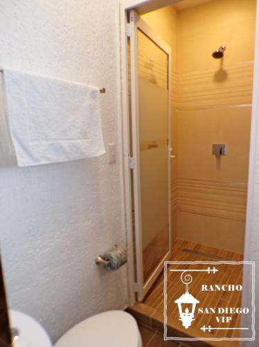 a bathroom with a toilet and a shower with a towel at Rancho San Diego, Villa llena de Vida VIP in Ixtapan de la Sal