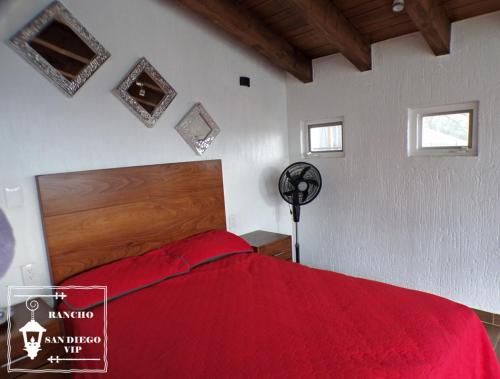 a bedroom with a bed with a red blanket at Rancho San Diego, Villa llena de Vida VIP in Ixtapan de la Sal