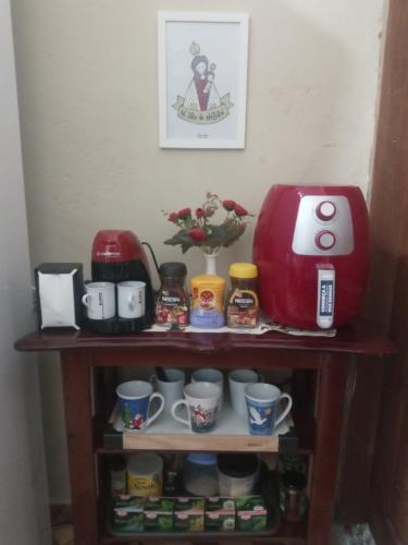 a shelf with cups and a coffee maker on it at Quarto espetacular próximo à UFPA e ao Centro comercial in Belém
