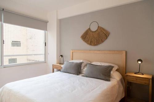 a bedroom with a white bed and a window at Ciprés Elegant Apartment in Buenos Aires