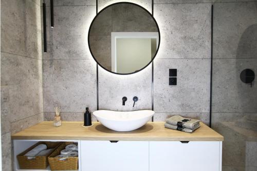 a bathroom with a sink and a mirror on a counter at Domek pod Lasem in Wapnica