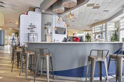 a bar in a restaurant with stools at Luxury 17th Floor 1 BR Condo Direct Oceanfront Wyndham Ocean Walk Resort Daytona Beach | 1708 in Daytona Beach