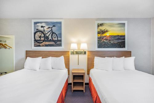 una habitación de hotel con 2 camas y una bicicleta en la pared en Days Inn by Wyndham Monticello, en Monticello