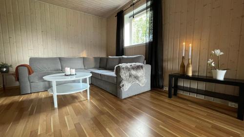 a living room with a couch and a table at Sentral og romslig leilighet nært Senja in Finnsnes
