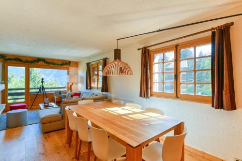 a living room with a wooden table and chairs at Ski nest - Pool - Mont Blanc view in Saint-Gervais-les-Bains