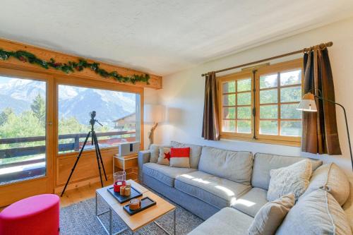 a living room with a couch and a camera at Ski nest - Pool - Mont Blanc view in Saint-Gervais-les-Bains