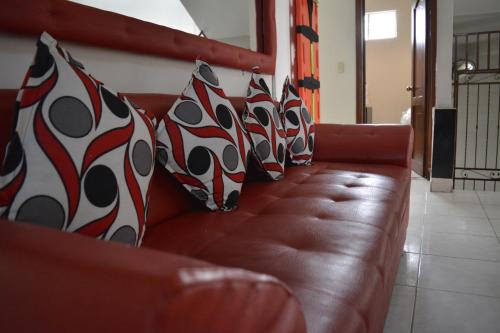 a brown couch with black and white pillows on it at Hotel La Mansión del Sol in Tuluá