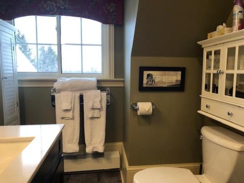 een badkamer met een wit toilet en een raam bij The Woodview Inn in Gananoque