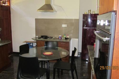a small kitchen with a table and a refrigerator at Caro Villa in Induruwa