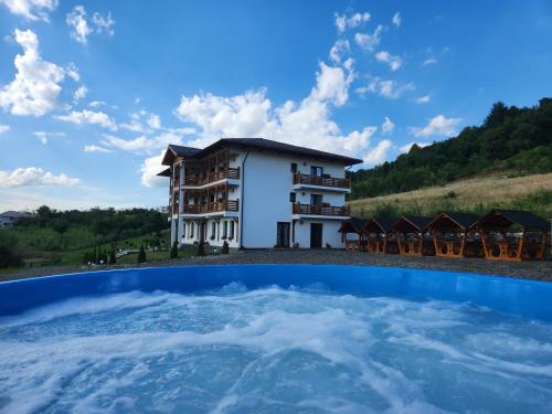 a view of a building from the water in front of a building at Pensiunea Hanul Morosenilor in Onceşti