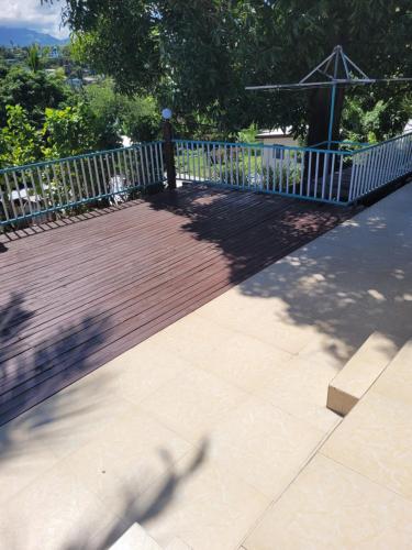 a wooden boardwalk with a fence and a bench at Holiday Home in Lautoka