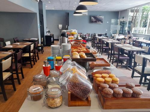 a long table with many different types of pastries at EXCELENTE Flat proximo Shoppings JK e Vila Olimpia in Sao Paulo