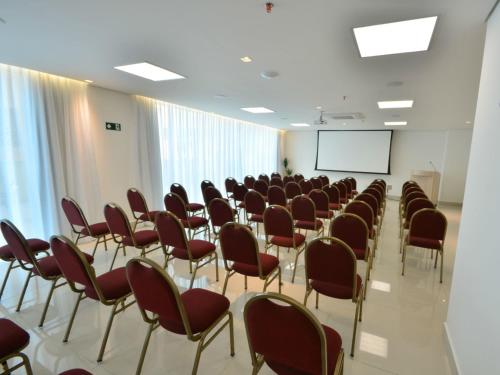 a room with chairs and a screen in it at IT Itabira Hotel in Itabira
