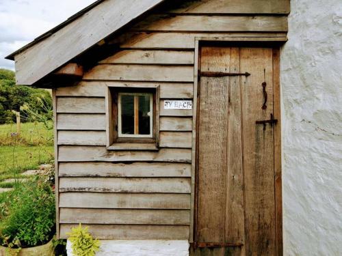 eine alte Holztür und Fenster auf einem Gebäude in der Unterkunft Cefnmachllys Shepherds Huts in Brecon