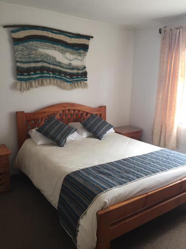 ein Schlafzimmer mit einem großen Bett mit zwei Kissen in der Unterkunft HOTEL MAUCHO PUCON in Pucón