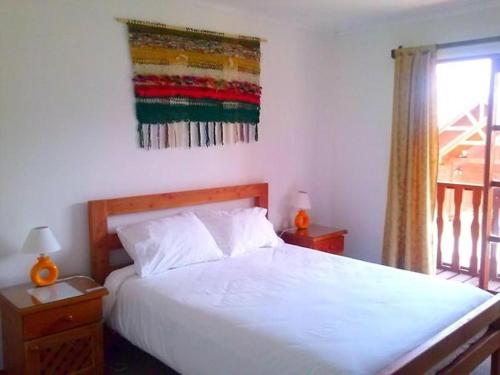 ein Schlafzimmer mit einem weißen Bett und einem Fenster in der Unterkunft HOTEL MAUCHO PUCON in Pucón