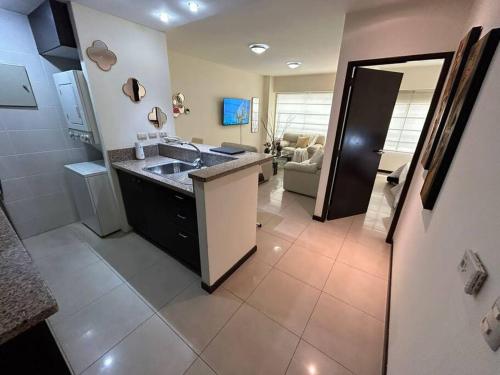 uma cozinha com um lavatório e uma sala de estar em Ecusuites Ejecutiva Torre Sol Aeropuerto IX em Guayaquil