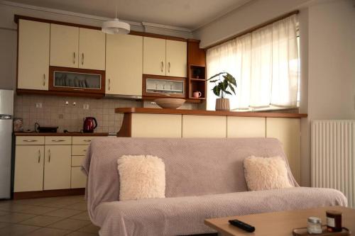 a living room with a couch and a kitchen at Groovy Apartment in Tripolis