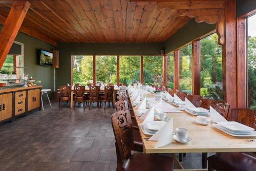 a dining room with a long table and chairs at Villa Bezycer in Gowidlino