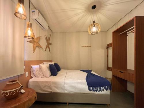 a bedroom with a bed with two lights and a table at Villa Sapê 9 in São Miguel dos Milagres