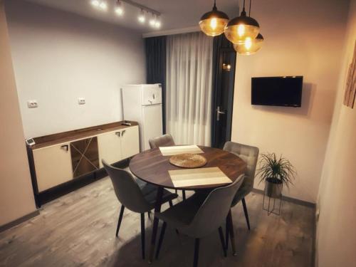 a dining room with a table and chairs and a refrigerator at RR Residence in Craiova