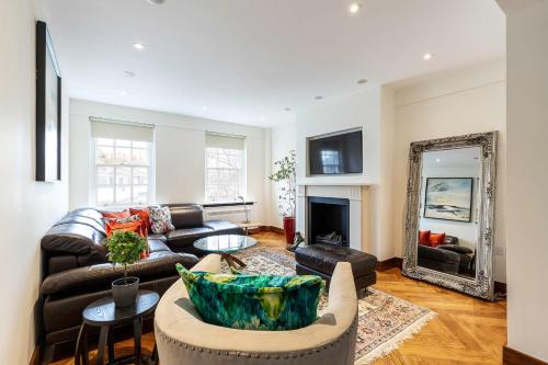 sala de estar con sofá de cuero y espejo en Colourful South Kensington Home, en Londres