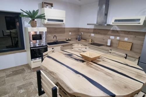 uma cozinha com uma mesa de madeira em Gite le 159 avec sauna et jacuzzi em Vesseaux