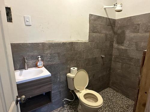 a bathroom with a toilet and a sink at Bonita cabaña estilo glamping in Juayúa