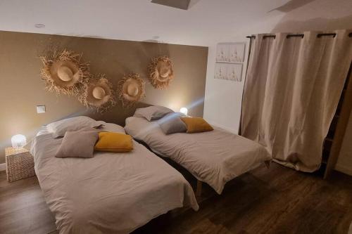 um quarto com 2 camas com espelhos na parede em Gite le 159 avec sauna et jacuzzi em Vesseaux