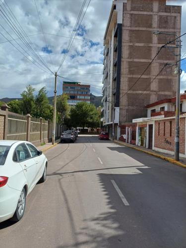 a white car parked on the side of a street at Posada de Mama in Cusco