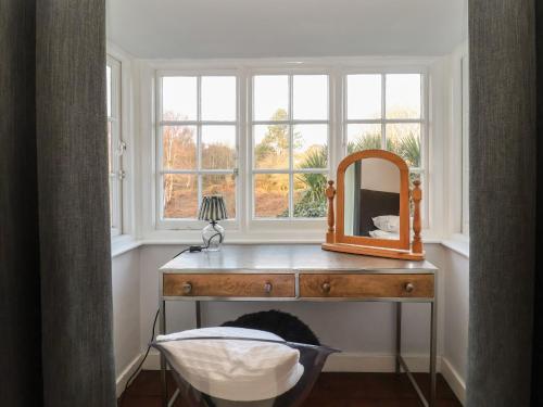 a mirror on a dresser in a room with a window at 6 The Whinlands in Leiston