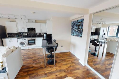 a kitchen and living room with a table and chairs at Lovely two bed flat with free parking (4 117) in Nottingham