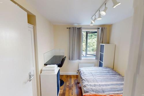 Habitación pequeña con cama y ventana en Lovely two bed flat with free parking (4 117) en Nottingham