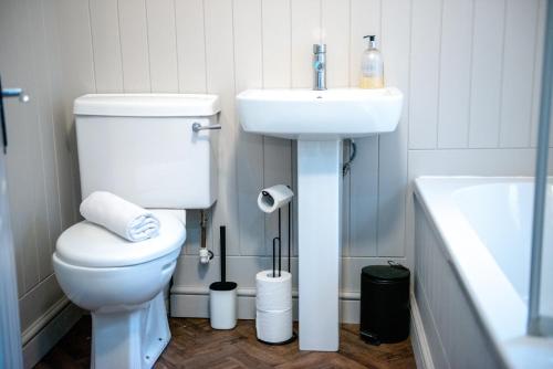 a bathroom with a white toilet and a sink at The Limes - Stylish City Centre Retreat in Peterborough