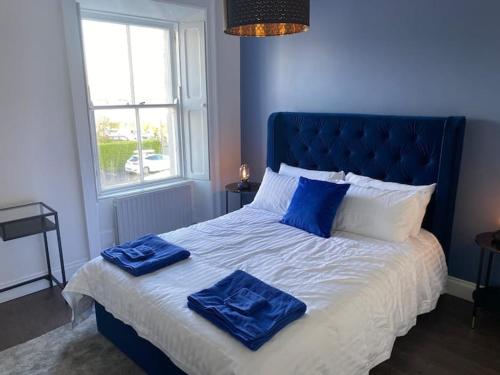 a blue bedroom with a bed with two blue towels on it at Stanley Place in Greystones