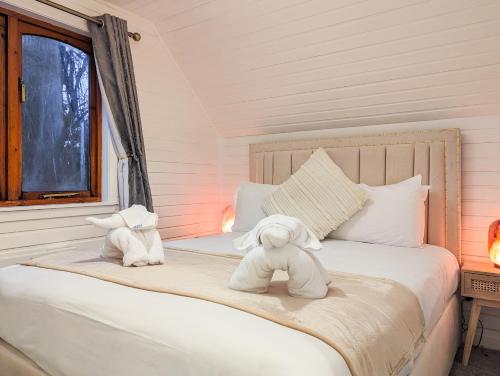 a bedroom with two stuffed animals on a bed at Boann 5 - Hot Tub-Hunting Tower Lodges-Luxury-Families-Romantic in Perth