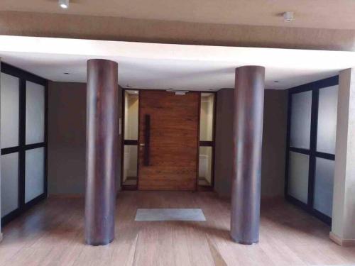 a room with two metal columns in a room with a door at Excelente departamento en pleno centro in Puerto Iguazú