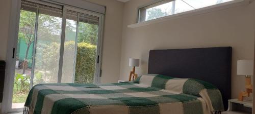 シエラ・デ・ラ・ベンターナにあるAlfonsina Holiday Homeのベッドルーム1室(緑と白の毛布付きのベッド1台付)
