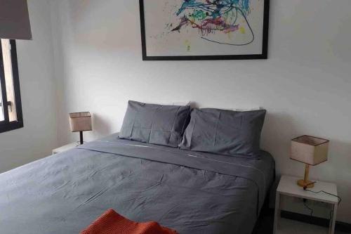 a bedroom with a bed and two lamps on tables at Excelente departamento en pleno centro in Puerto Iguazú