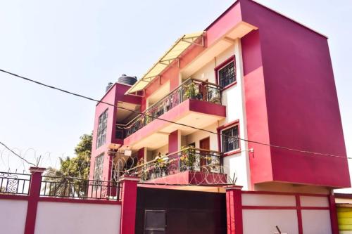 un edificio rojo y blanco con balcones en 6 Appartements/ 6 studios privé à Bangui RESIDENCE RENESSIOT en Bangui