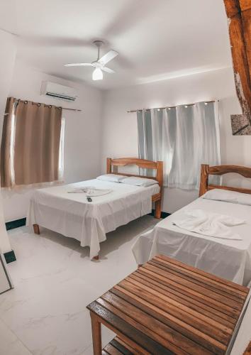 a room with two beds and a table in it at Hotel Sanches in São Mateus