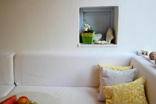 a white couch with a mirror and a bowl of fruit at Sanoudos in Naxos Chora