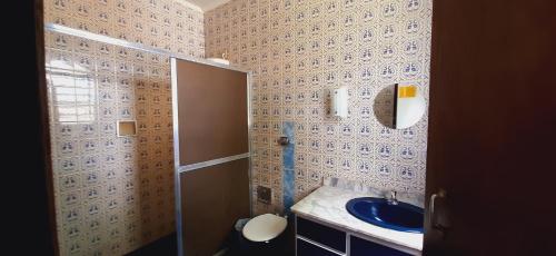 uma casa de banho com um lavatório azul e um espelho. em Chácara Monteiro - Próximo ao Thermas Water Park em São Pedro