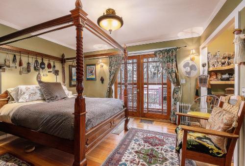 a bedroom with a canopy bed and a chair at Burnt Toast Inn in Ann Arbor