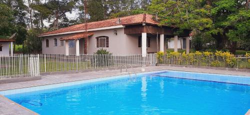 una gran piscina azul frente a una casa en Chácara Monteiro - Próximo ao Thermas Water Park en São Pedro