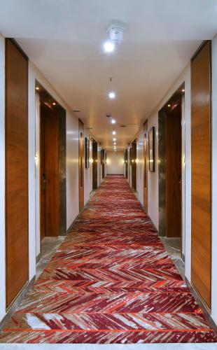 a long hallway with a red carpet on the floor at The Fern Residency Ajmer in Ajmer