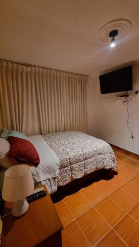 a bedroom with a bed and a flat screen tv at Lili´s House in Huaraz