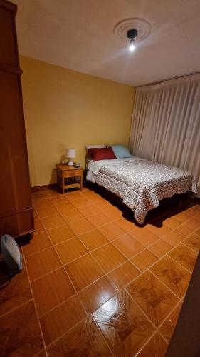a bedroom with a bed and a tiled floor at Lili´s House in Huaraz