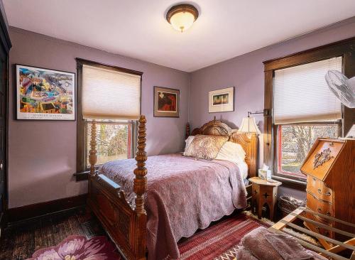 a bedroom with a bed and two windows at Burnt Toast Inn in Ann Arbor